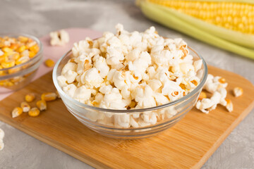 Prepared popcorn with ingredients on wooden table