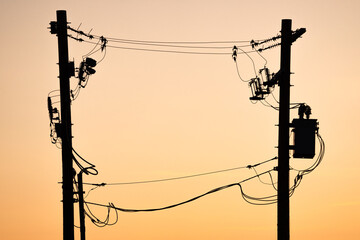 Power pole silhouette of transmission lines at sunset In Alberta Canada. - obrazy, fototapety, plakaty