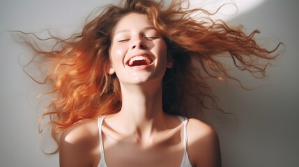 Naklejka premium Portrait of a laughing red-haired young woman. Joy and happiness concept.