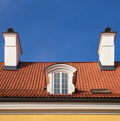 Old vintage garret roof with window and chimneys. Retro attic window and fireplace chimneys, Riga,...