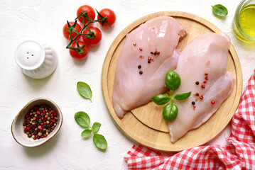 Raw organic chicken fillet on a wooden cutting board . Top view with copy space.