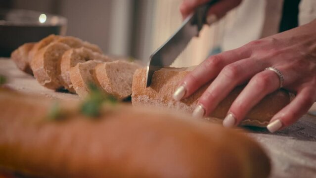 Close-up of a French baguette being sliced. catering for the holidays, holiday hors d'oeuvres. High quality 4k footage