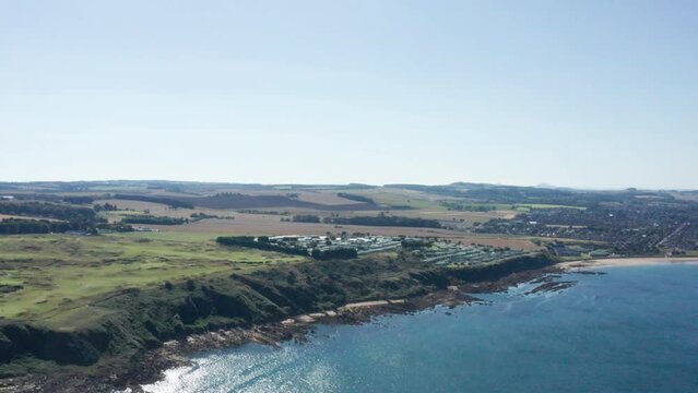 Drone shot of the coastline in Scotland, clear blue skies and vast country side