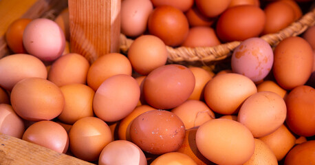 Image of raw fresh eggs in wicker basket at grocery store, nobody