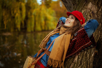 relaxed elegant female in jeans shirt and red hat with scarf