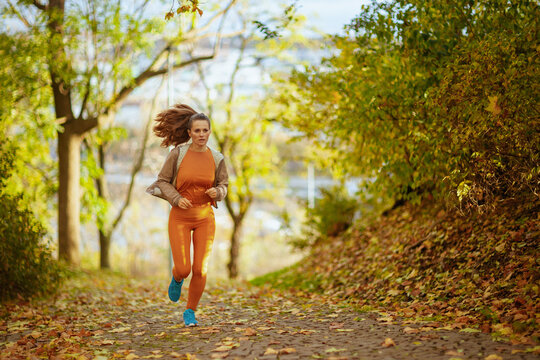 elegant woman in fitness clothes in park running