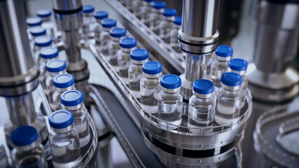 3d render, conveyor with the glass jars, modern pharmaceutical factory. Closeup of ampules are being filled with vaccine and closed with blue caps. Medical wallpaper - 652070567