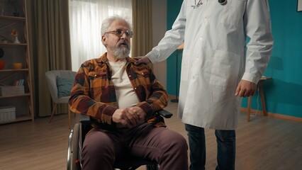 Medium shot of a handicapped eldery patient on a wheelchair having a medical check up at home. The...