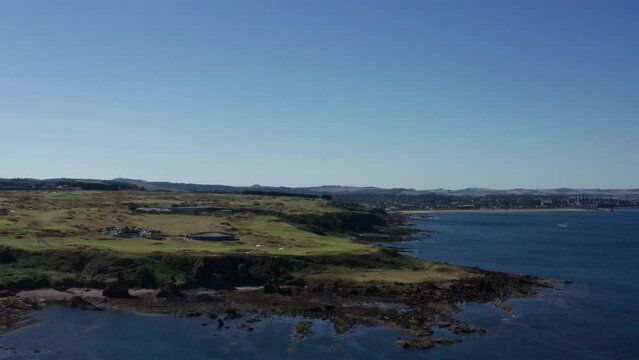 Drone shot of the coastline in Scotland, clear blue skies and vast country side
