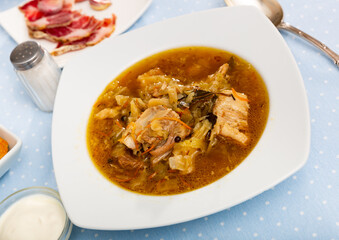 Thick Russian-style cabbage soup (Shchi) with pork cooked in mushroom broth served with sour cream..
