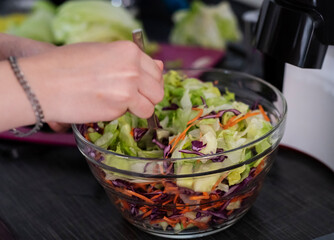 Woman cuts lettuce leaves in the kitchen
