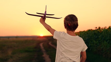 Kid, become an airplane pilot, Happy boy child runs with toy plane sunset. Child dream to fly. Boy...