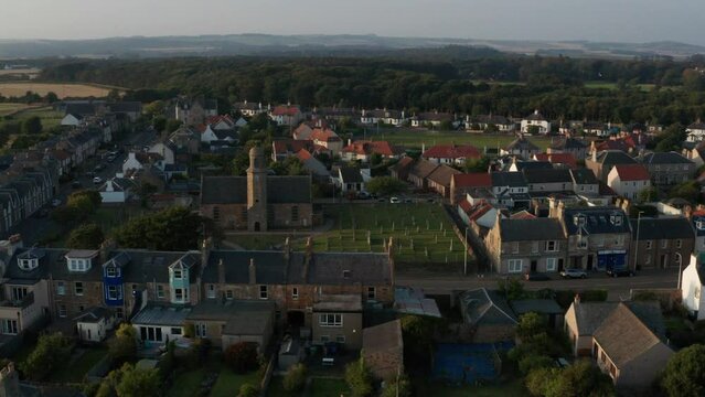 Aerial shot of a Scotland town by the water at sunset