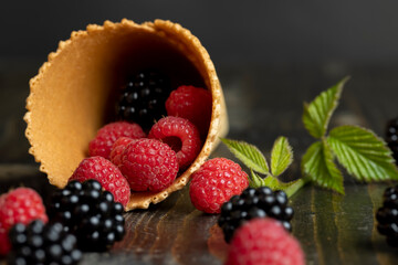 Ripe red raspberries in a crispy waffle cone