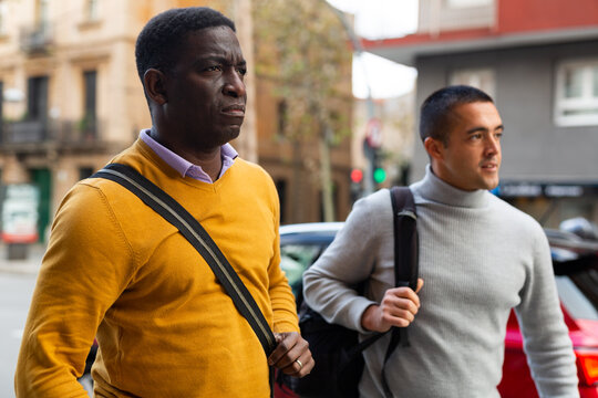 African-american and European men going through town streets.