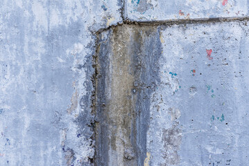 A wall with peeling paint and moisture stains