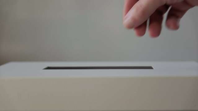 A person casts her ballot during voting for elections at a polling station. Close up shot