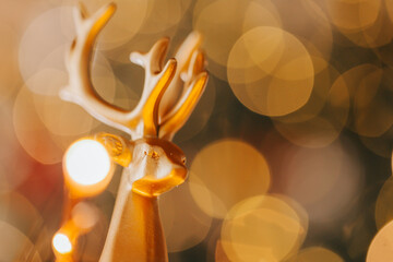  figurine of a Christmas golden deer on golden bokeh background.Christmas gold deer. Decorating...