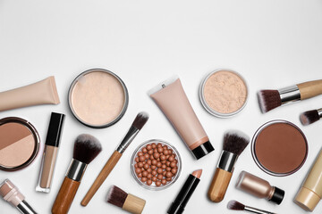 Face powders and other makeup products on white background, flat lay