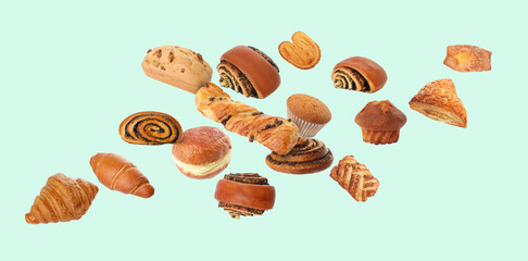 Aromatic fresh pastries falling on pale turquoise background