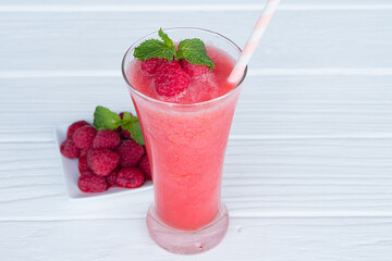 Raspberry smoothie red colorful fruit juice milkshake blend beverage healthy high protein the taste yummy In glass drink episode morning on white wood background.