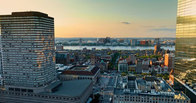 Flying between two beautiful tower blocks and opening view on the Charles River in Boston. Panorama of the city from top at sunset.