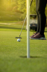 Woman Putting on the Green with Golden Sun Light