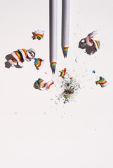 Lead pencil with colourful shavings on white.