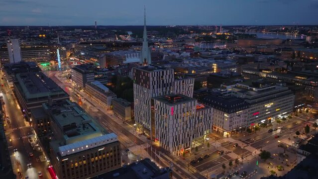 Aerial view of mixture of modern and historic town development. Futuristic tall hotel buildings neighbouring with historic church. Cityscape at dusk. Stockholm, Sweden