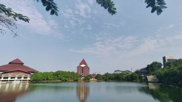 Depok, Indonesia - June 29, 2023: View of the Kenanga lake with the background of an University of Indonesia building at Depok, Indonesia. Clear blue sky.