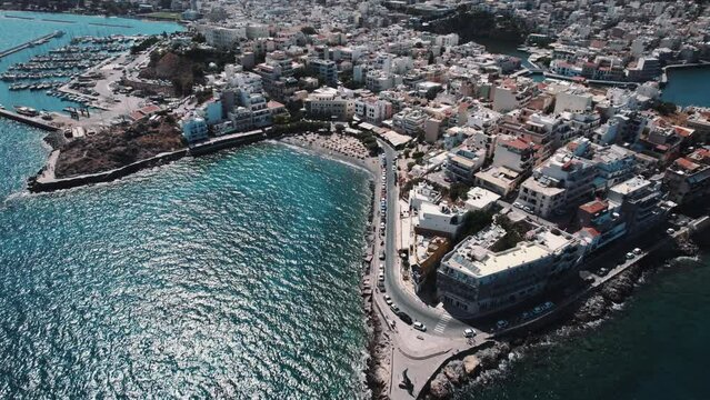 A slow-motion aerial view of Agios Nikolaos on the Greek island of Crete. Drone circling around the port. High quality 4k footage