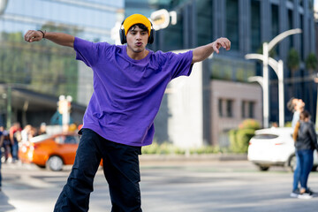 Dancing latino young man with headphones listening to music performing various freestyle dance...