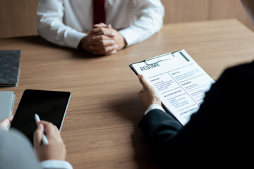 HR manager woman reading resume and writing data on tablet during job interview with male candidate