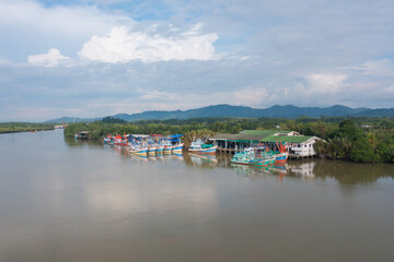 Fototapeta na wymiar Aerial view of fishing trap net in canel with fisherman urban city village town houses, lake or river. Nature landscape fisheries and fishing tools at Pak Pha, Songkhla, Thailand. Aquaculture farming