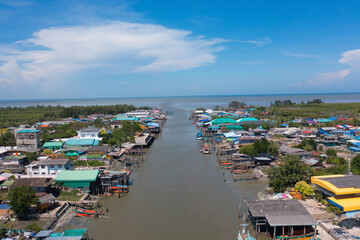 Obraz premium Aerial view of fishing trap net in canel with fisherman urban city village town houses, lake or river. Nature landscape fisheries and fishing tools at Pak Pha, Songkhla, Thailand. Aquaculture farming
