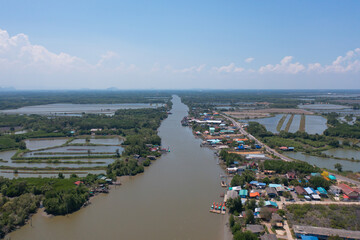 Aerial view of fishing trap net in canel with fisherman urban city village town houses, lake or river. Nature landscape fisheries and fishing tools at Pak Pha, Songkhla, Thailand. Aquaculture farming
