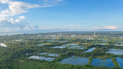 Aerial view of wind turbines or windmills farm field and sea shore beach in industry factory. water...