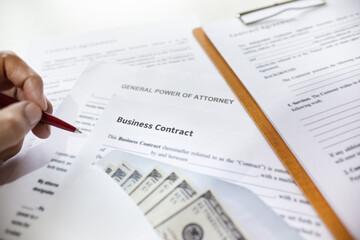 Close-up view, business contrack document with dollar in white envelope on desk and hand holding...