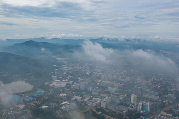 Aerial view of residential neighborhood roofs with fog mist in rainy season. Urban housing development from above. Top view. Real estate in Phuket, southern province city, Thailand.