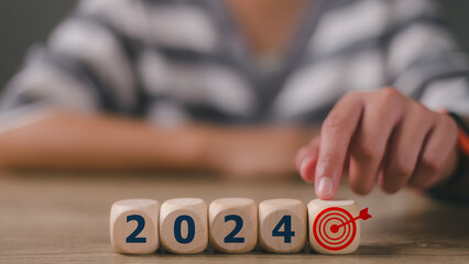 Businesswoman touching target icon wooden block cube from  2024 setup objective target business...