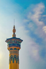 Fototapeta na wymiar the minaret of a mosque against a backdrop of blue sky and cloudy twilight