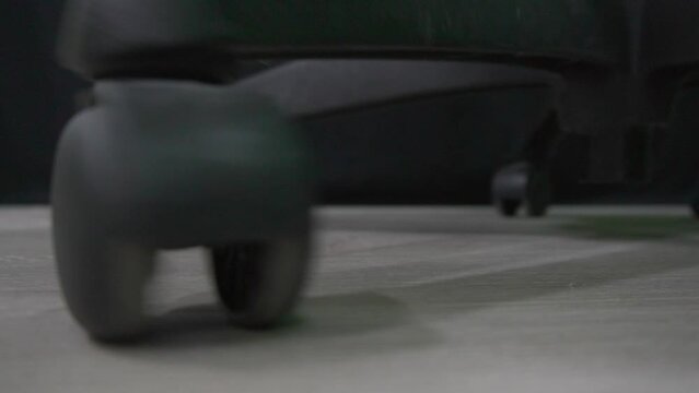 Black plastic wheel of office chair moving on ground floor at office indoor