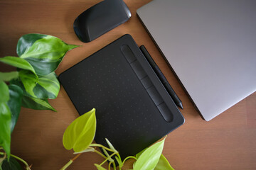 Laptop and graphics tablet on a green background on the table.
