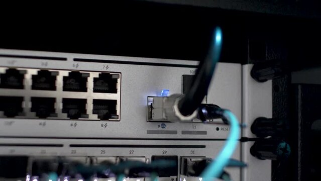 Close Up Shot Of Fibre Optic Cable Plugged In Network Server Rack With White Blinking Lights. Static Shot
