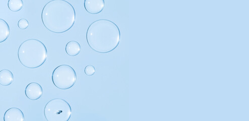 round drops of transparent gel serum on blue background