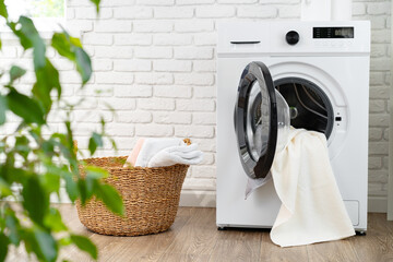 Modern white washing machine in a laundry room - obrazy, fototapety, plakaty