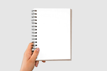 Female Hand Holding Notepad with Blank Page Isolated On Gray Neutral Studio Background. Close Up....
