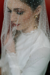 Bride in polka dot veil, vintage gown, and red lipstick.