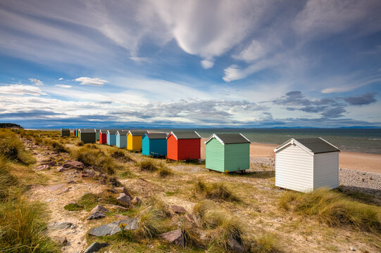Colorful wooden beach huts at Findhorn beach, Moray coast, Scotl