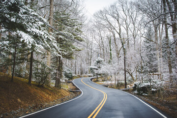 Snowy winter scene, showing curved street in rural landscape.